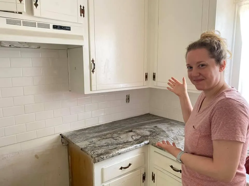 Emmy Jones showing the finished duplex kitchen with new countertops and backsplash